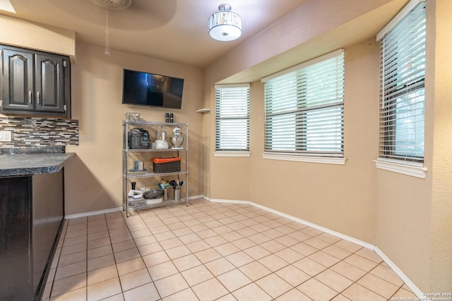 interior space with baseboards and light tile patterned floors