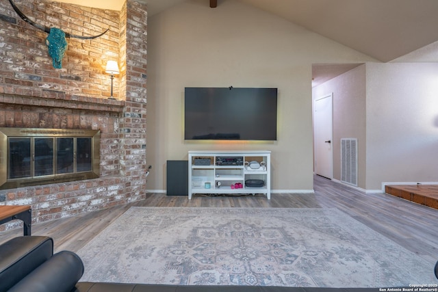 living room featuring baseboards, visible vents, wood finished floors, and high vaulted ceiling