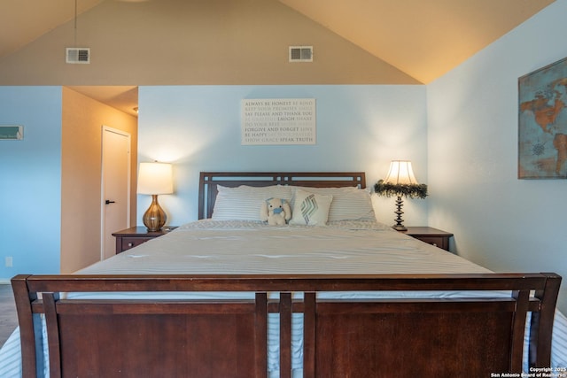 bedroom with high vaulted ceiling, visible vents, and wood finished floors