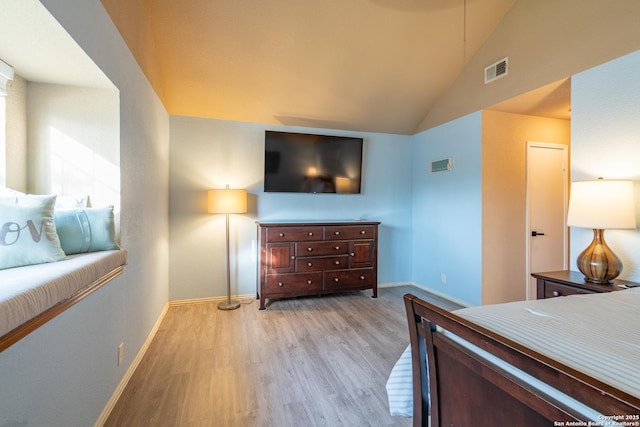bedroom featuring baseboards, vaulted ceiling, light wood-type flooring, and visible vents
