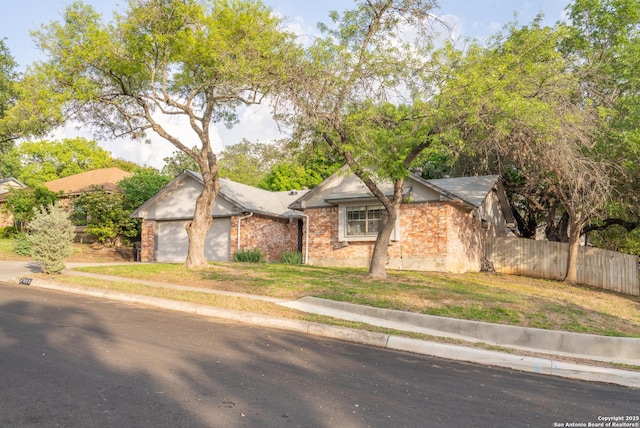 single story home featuring fence, a front lawn, and brick siding