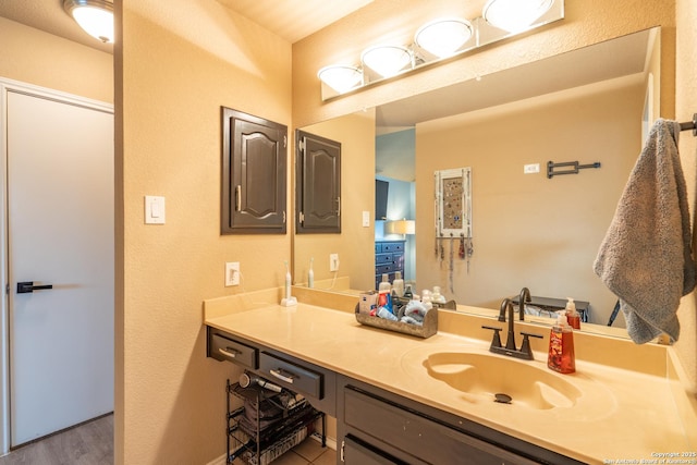 bathroom featuring vanity, baseboards, and wood finished floors