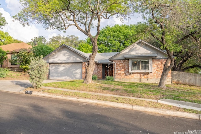 ranch-style home featuring driveway, a garage, brick siding, fence, and a front lawn