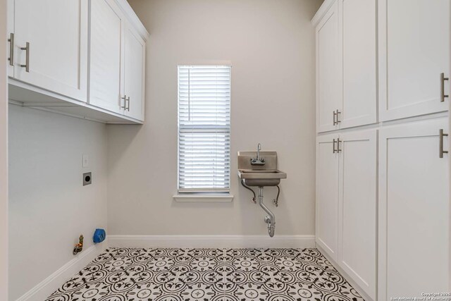 8314 Marek, San Antonio, TX 78224 - clothes washing area with cabinet space, hookup for an electric dryer, and baseboards