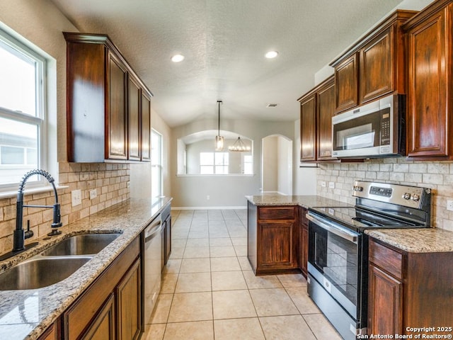 kitchen featuring a sink, stainless steel appliances, baseboards, recessed lighting, and decorative backsplash