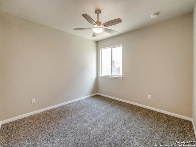 carpeted spare room featuring ceiling fan and baseboards