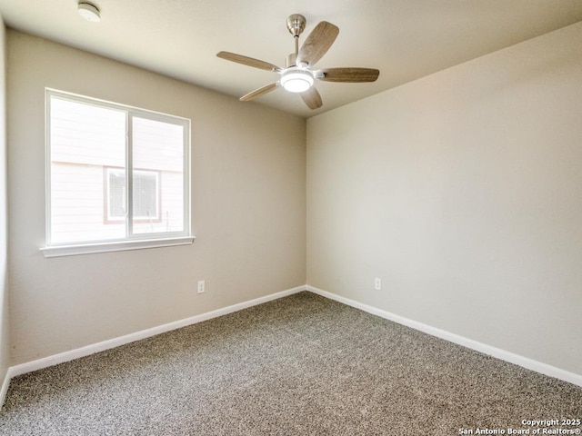 carpeted spare room featuring ceiling fan and baseboards