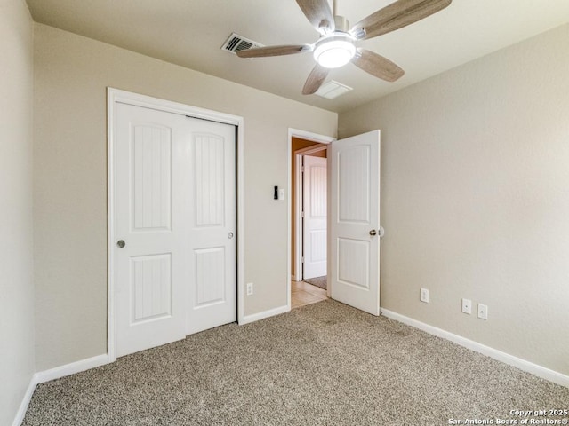 unfurnished bedroom featuring a ceiling fan, visible vents, baseboards, a closet, and carpet flooring