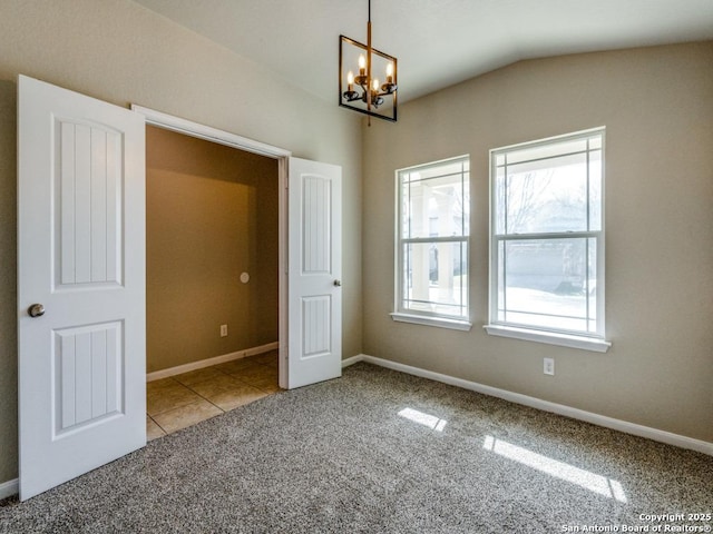 interior space with carpet, vaulted ceiling, a chandelier, and a wealth of natural light
