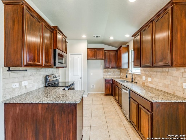 kitchen featuring visible vents, light stone countertops, a sink, appliances with stainless steel finishes, and vaulted ceiling