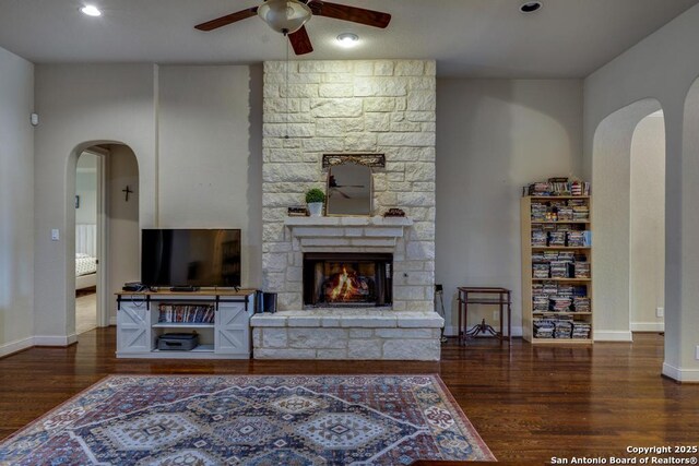 730 San Anza, San Antonio, TX 78260 - living room with arched walkways, ceiling fan, a stone fireplace, and wood finished floors