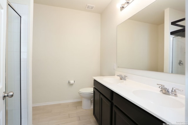 bathroom with double vanity, toilet, visible vents, and a sink