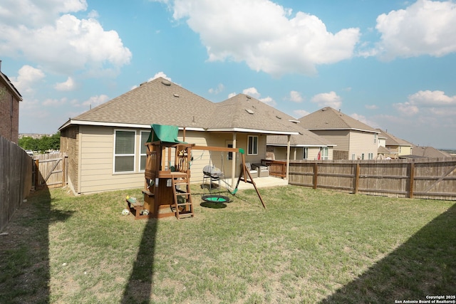 back of property featuring a patio, a fenced backyard, a playground, and a yard