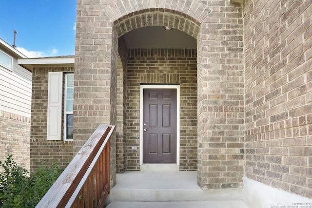 doorway to property with brick siding