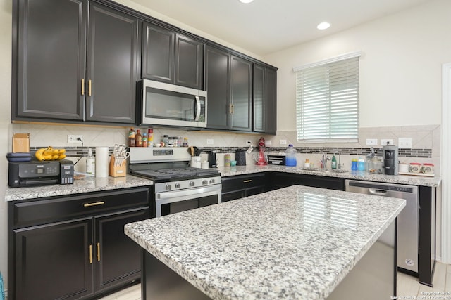 kitchen with a sink, appliances with stainless steel finishes, and dark cabinets
