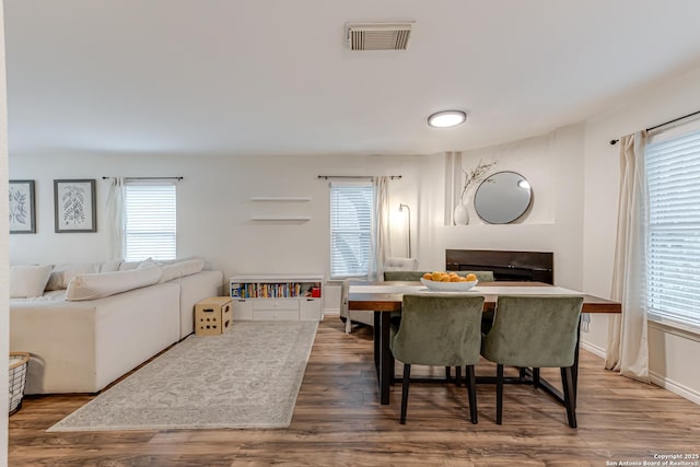dining area featuring plenty of natural light, wood finished floors, and visible vents