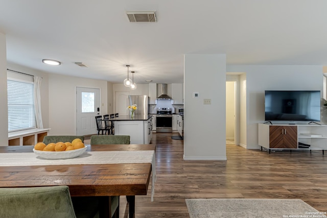 dining room with baseboards, wood finished floors, and visible vents