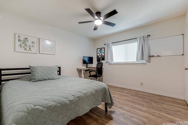 bedroom with baseboards, ceiling fan, and wood finished floors