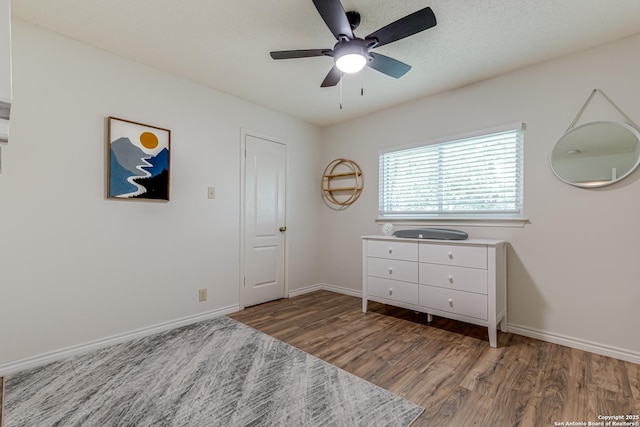 bedroom with baseboards, a ceiling fan, and light wood-style flooring