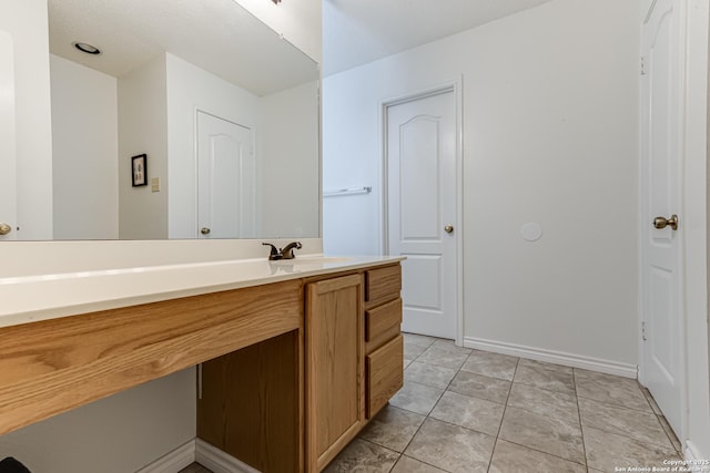 bathroom featuring vanity, baseboards, and tile patterned floors