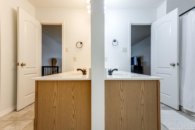 full bath featuring a sink and two vanities