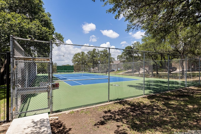 view of tennis court with a gate and fence