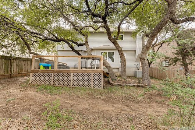back of property with a fenced backyard and a deck