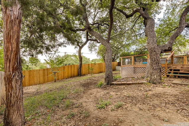 view of yard with a fenced backyard and a wooden deck