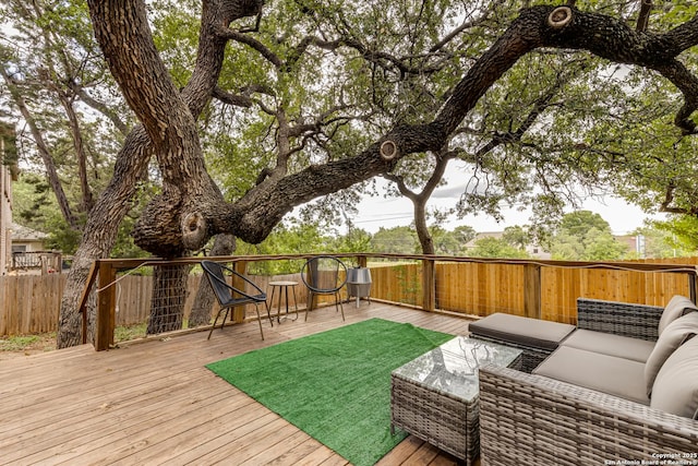 wooden terrace featuring a fenced backyard and an outdoor living space