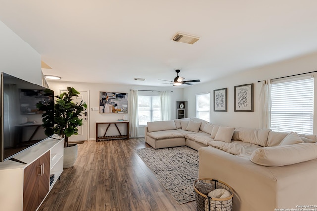 living area with ceiling fan, wood finished floors, and visible vents