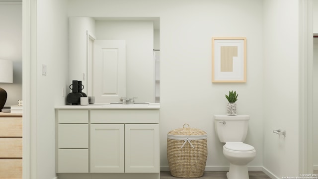 bathroom with vanity, baseboards, and toilet