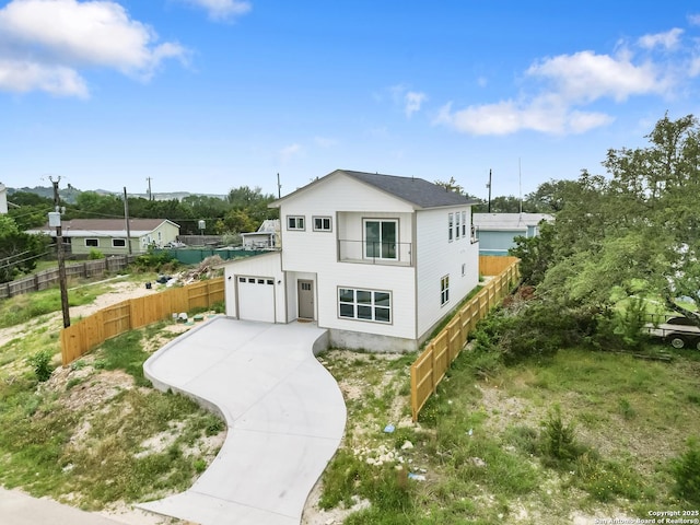 view of front facade featuring a garage, fence, and driveway