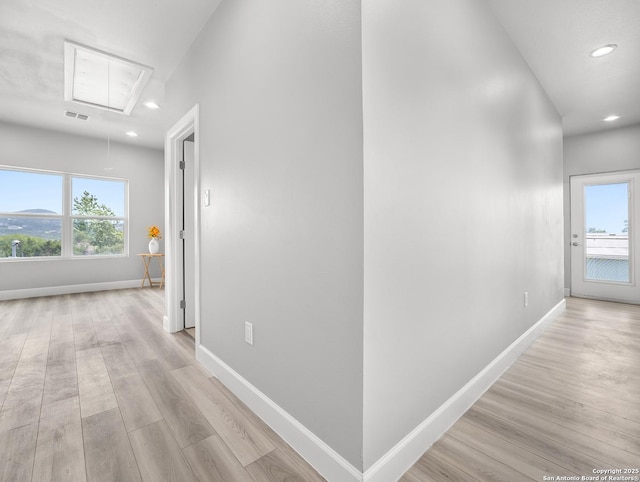 hallway featuring visible vents, light wood-style floors, attic access, baseboards, and recessed lighting
