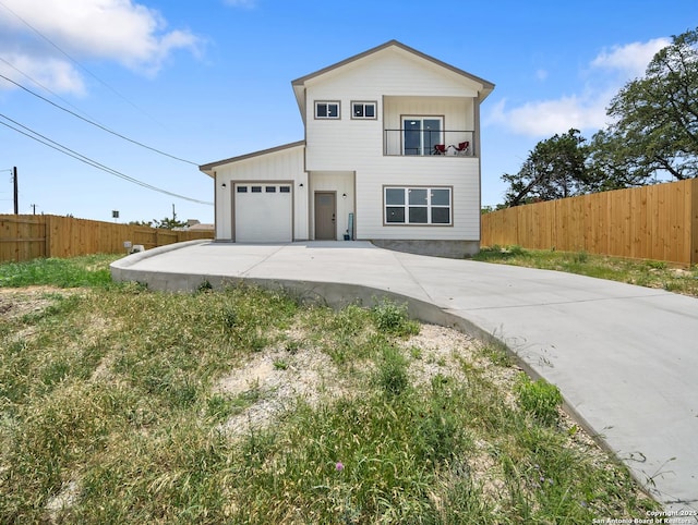 view of front facade with a garage, fence, and driveway
