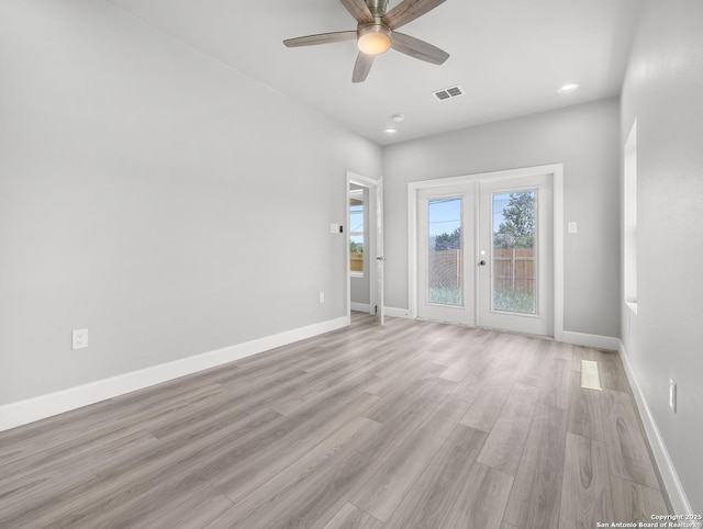 empty room with visible vents, baseboards, ceiling fan, light wood-type flooring, and french doors