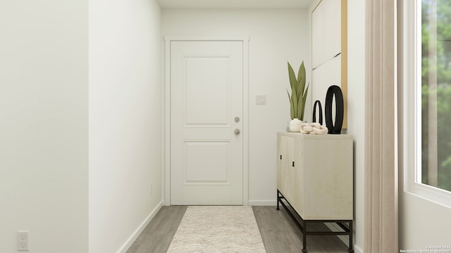 doorway featuring baseboards and light wood finished floors