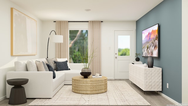 living area with baseboards, plenty of natural light, and wood finished floors
