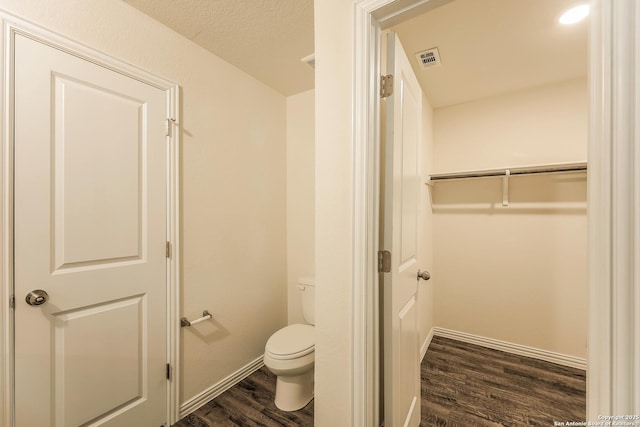 2430 Bermuda, San Antonio, TX 78222 - bathroom with toilet, baseboards, visible vents, and wood finished floors