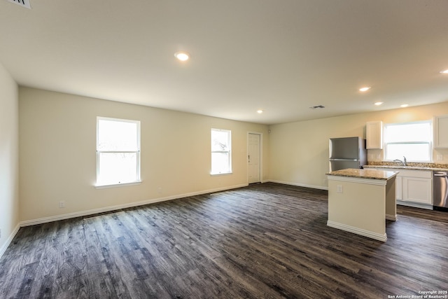 2430 Bermuda, San Antonio, TX 78222 - kitchen featuring dark wood-style flooring, freestanding refrigerator, a wealth of natural light, stainless steel dishwasher, and a kitchen island