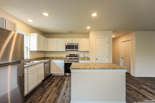 2430 Bermuda, San Antonio, TX 78222 - kitchen with appliances with stainless steel finishes, white cabinets, a center island, and dark wood-style flooring