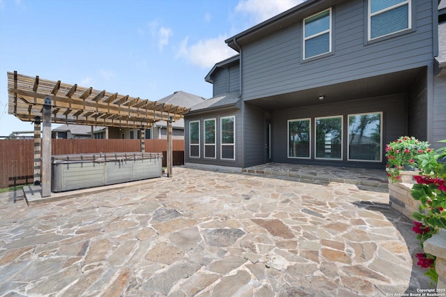 view of patio / terrace featuring a hot tub, a pergola, and fence