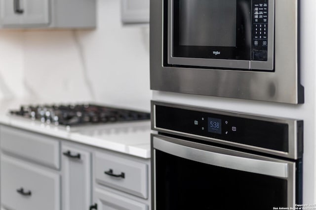 room details with light countertops, stainless steel appliances, and white cabinets