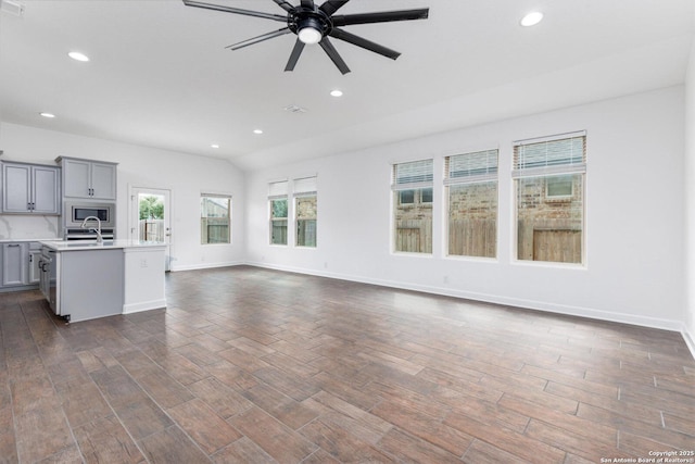 unfurnished living room featuring a ceiling fan, baseboards, recessed lighting, and dark wood-type flooring