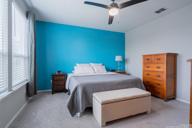 bedroom featuring visible vents, multiple windows, and light colored carpet