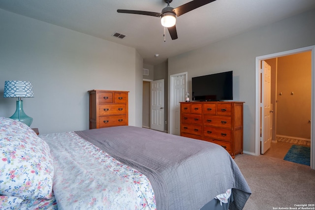 carpeted bedroom featuring a ceiling fan and visible vents
