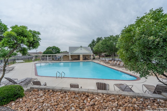 community pool with fence and a patio area