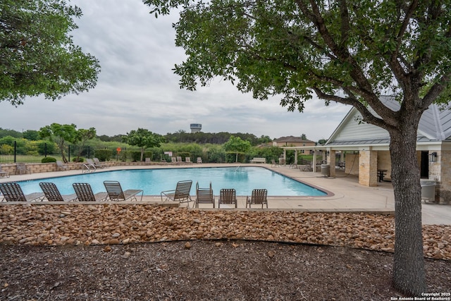 community pool with fence and a patio
