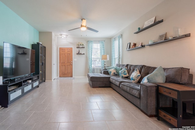 living room featuring baseboards, ceiling fan, and light tile patterned flooring