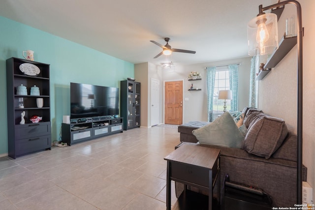 living area featuring light tile patterned floors, baseboards, and a ceiling fan