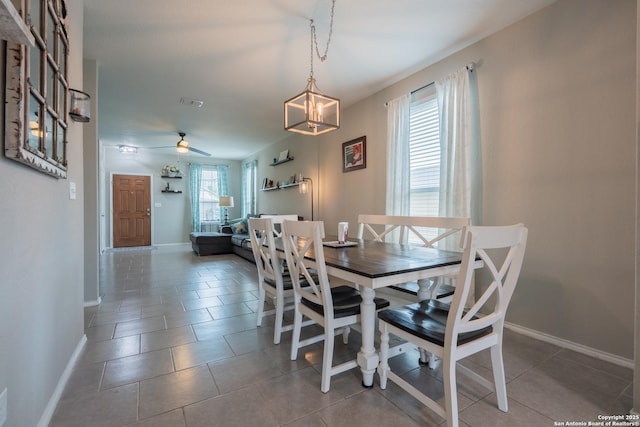 dining space featuring baseboards, ceiling fan with notable chandelier, and tile patterned floors